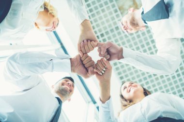 Dört mutlu iş adamı bir yumrukla selamlaşıyor.