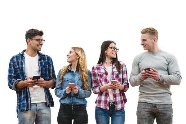 Quatro Pessoas Felizes Com Telefones Estão Fundo Parede Branca — Fotografia de Stock