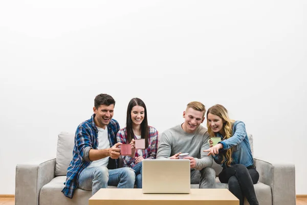 Quatro Pessoas Felizes Com Copos Sentar Perto Laptop Fundo Parede — Fotografia de Stock