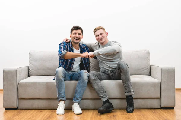 Dois Homens Felizes Gesto Sofá Fundo Parede Branca — Fotografia de Stock