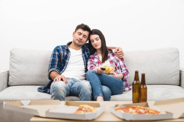 Beyaz arka planda, koltukta oturan uyuyan çift.