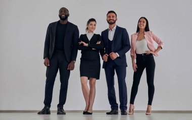 Beyaz duvar arkasında duran iş adamları.