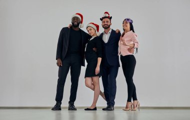 Beyaz duvarın arkasında duran kırmızı şapkalı iş adamları.