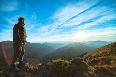 Güzel dağ manzarasında duran mutlu adam.