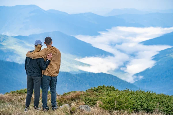 女性と男が山の風景の背景に立っている — ストック写真