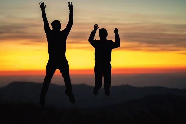 Mies Nainen Hyppivät Vuorella Auringonlaskun Taustalla — kuvapankkivalokuva