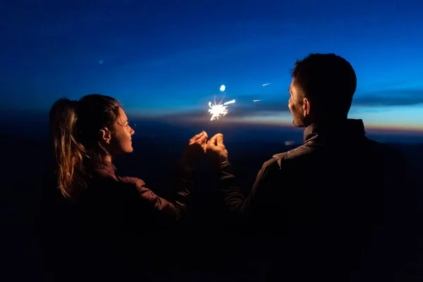 Das Glückliche Paar Hält Feuerwerkskörper Auf Dem Hintergrund Des Sonnenaufgangs — Stockfoto