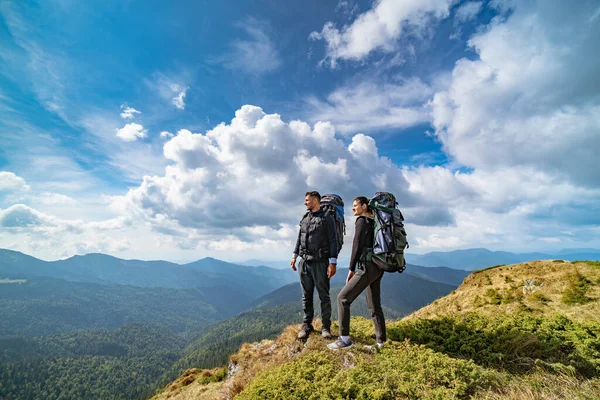 絵のように美しい雲の背景にある山の上の若いカップル — ストック写真