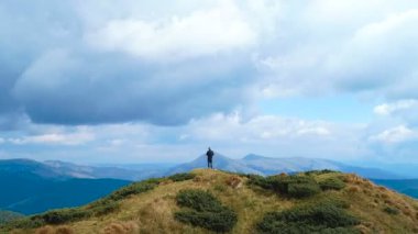 Dağın tepesinde duran erkek.