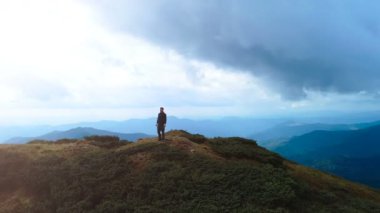 Dağın tepesinde güzel bir manzarası olan adam.