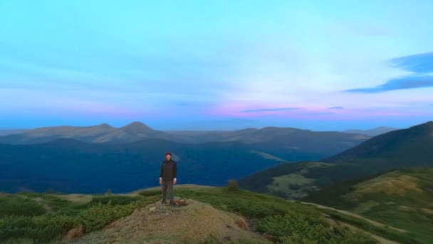 絵のように美しい夕日の山の頂上に立つ幸せな男 — ストック動画