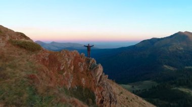 Dağ yamacında duran mutlu adam