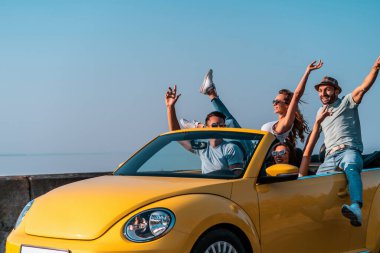 Arkadaşları bir Cabriolet 'le seyahat ederken eğleniyor.