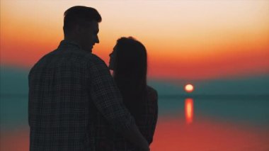 Genç çift güzel günbatımına karşı