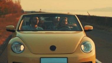 Genç arkadaşlar sarı bir Cabriolet ile seyahat ediyorlar. yavaş çekim