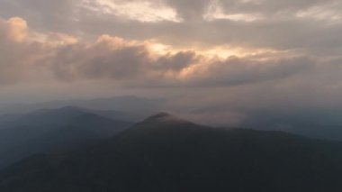 Günbatımı arka planında bir dağın tepesindeki uçuş. Hiperlapse