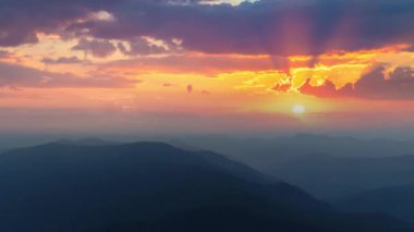 Günbatımı arka planındaki sisli dağların üzerindeki uçuş. Hiperlapse