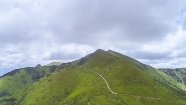 雲のストリームの背景にある緑の山の上の飛行 過経過 — ストック動画