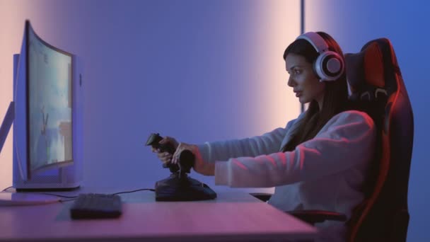 ヘッドフォン付きの美しいゲーマーの女の子はビデオゲームをプレイ — ストック動画