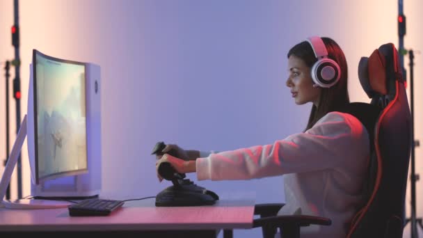 青い光スタジオでビデオゲームをプレイヘッドフォンを持つゲーマーの女の子 — ストック動画