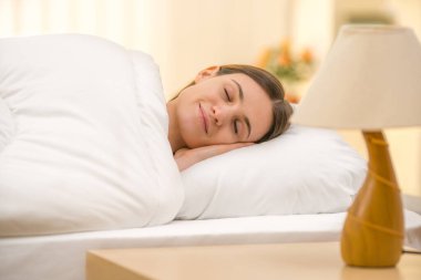 Komodinin arkasında uyuyan kadın.