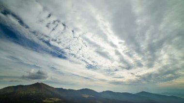 Bulut dağların üzerinden akar. Akşam vakti.