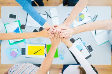 Altı kişi masaüstünde el kol hareketi yapıyor. Yukarıdan görünüm