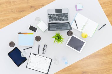 Bilgisayarı, tabletleri ve defterleri olan iş yeri. Yukarıdan görünüm