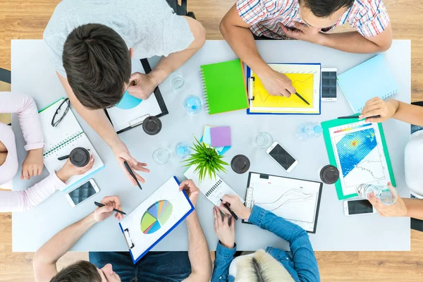 The six people work at the table. view from above