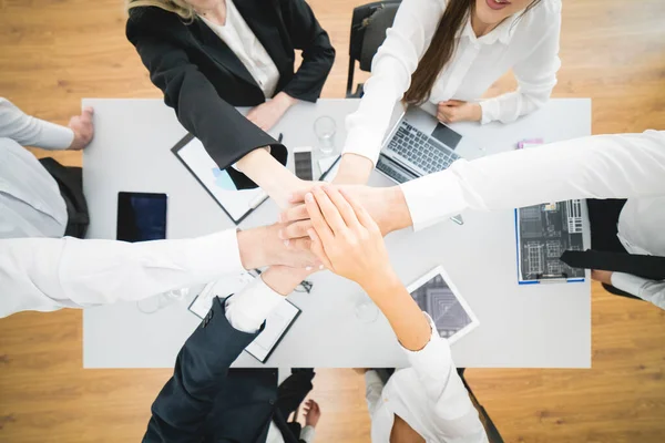 The six business people hold hands on a background of a desktop. view from above