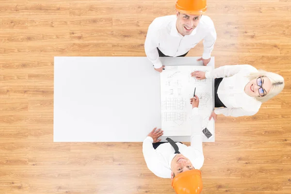 Los Tres Ingenieros Trabajan Con Plano Sobre Mesa Vista Desde —  Fotos de Stock