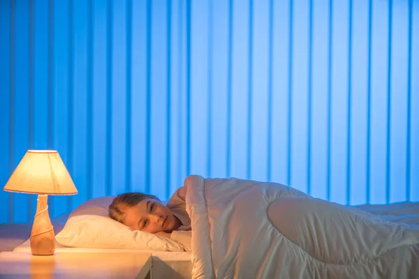 Yatakta uyuyan genç kız. Akşam vakti.