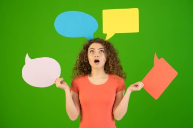 The surprised woman hold a dialog signs on the green background