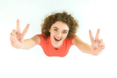 The cute woman show two finger to the camera. View from above