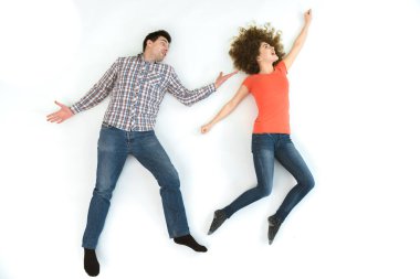 The happy couple gesture on the white floor. View from above