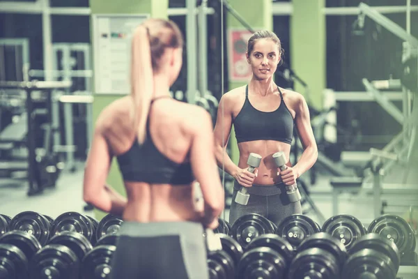 Spor Salonundaki Dambılı Kadın Aynanın Önünde Duruyor — Stok fotoğraf