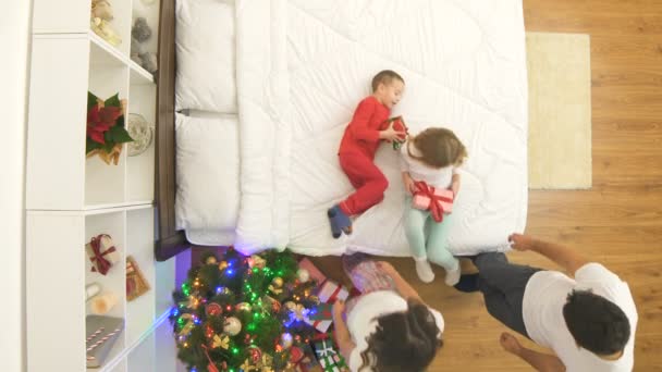 Familia Feliz Desempaquetar Regalos Cama Cerca Árbol Navidad Vista Desde — Vídeo de stock