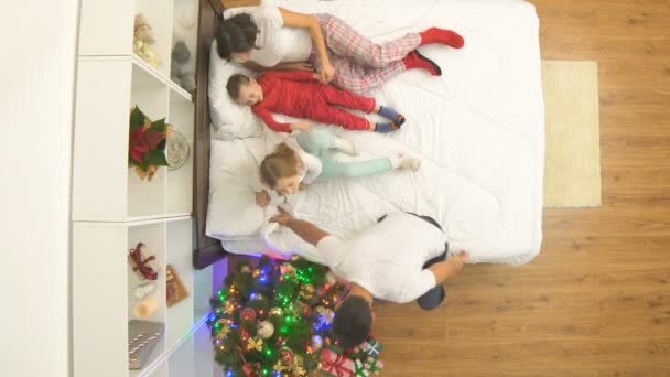 Gelukkige Familie Opent Geschenken Het Bed Bij Een Kerstboom Zicht — Stockvideo