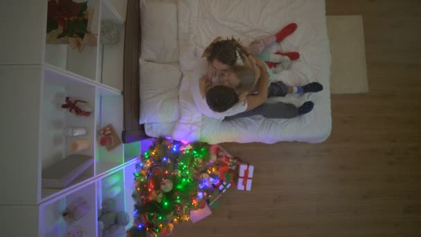 这个女孩在一棵圣诞树旁送给她的父母一份礼物 傍晚时分 — 图库视频影像