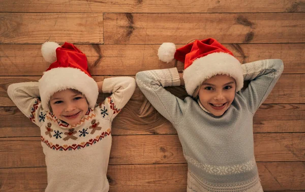 Szczęśliwe Dzieci Czerwonych Kapeluszach Leżące Podłodze — Zdjęcie stockowe