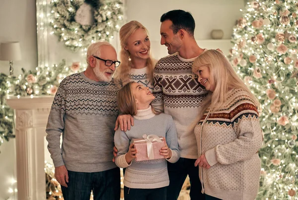 The happy family standing on the christmas tree background