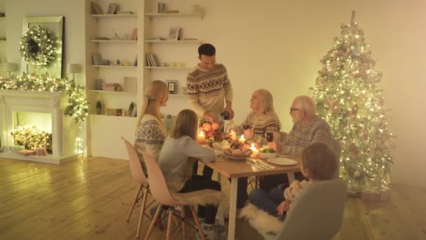 Οικογένεια Που Κάθεται Στο Τραπέζι Κοντά Στο Χριστουγεννιάτικο Δέντρο — Αρχείο Βίντεο