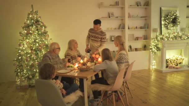 Gelukkige Familie Zit Aan Tafel Bij Kerstboom — Stockvideo