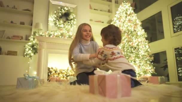 Маленькая Девочка Мальчик Играют Полу Фоне Рождественской Елки — стоковое видео