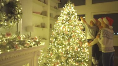 Mutlu aile Noel ağacını süslüyor. yavaş çekim