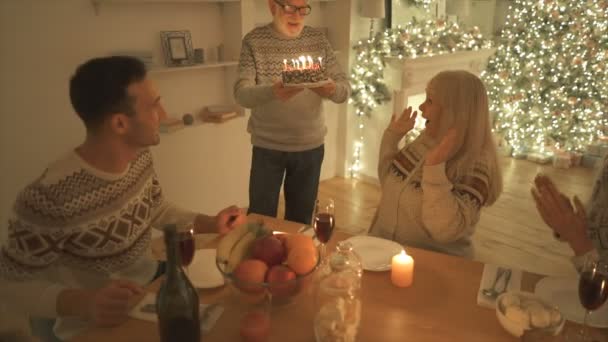 Oudere Man Geeft Een Verjaardagstaart Met Kaarsen Aan Zijn Vrouw — Stockvideo