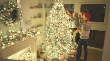 Mutlu aile Noel ağacını süslüyor. yavaş çekim