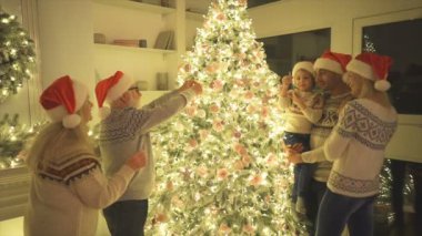 Aile güzel Noel ağacını süslüyor. yavaş çekim