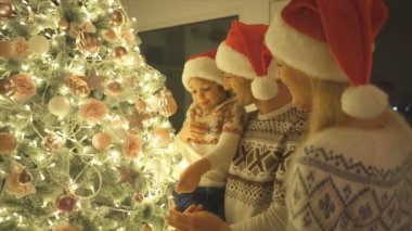 Mutlu aile, güzel Noel ağacını süslüyor. yavaş çekim
