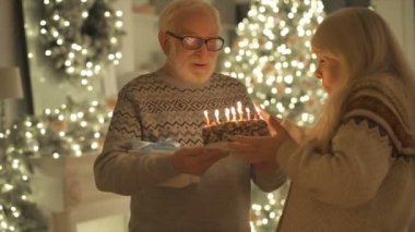Mutlu yaşlı adam bir kadına pasta veriyor.